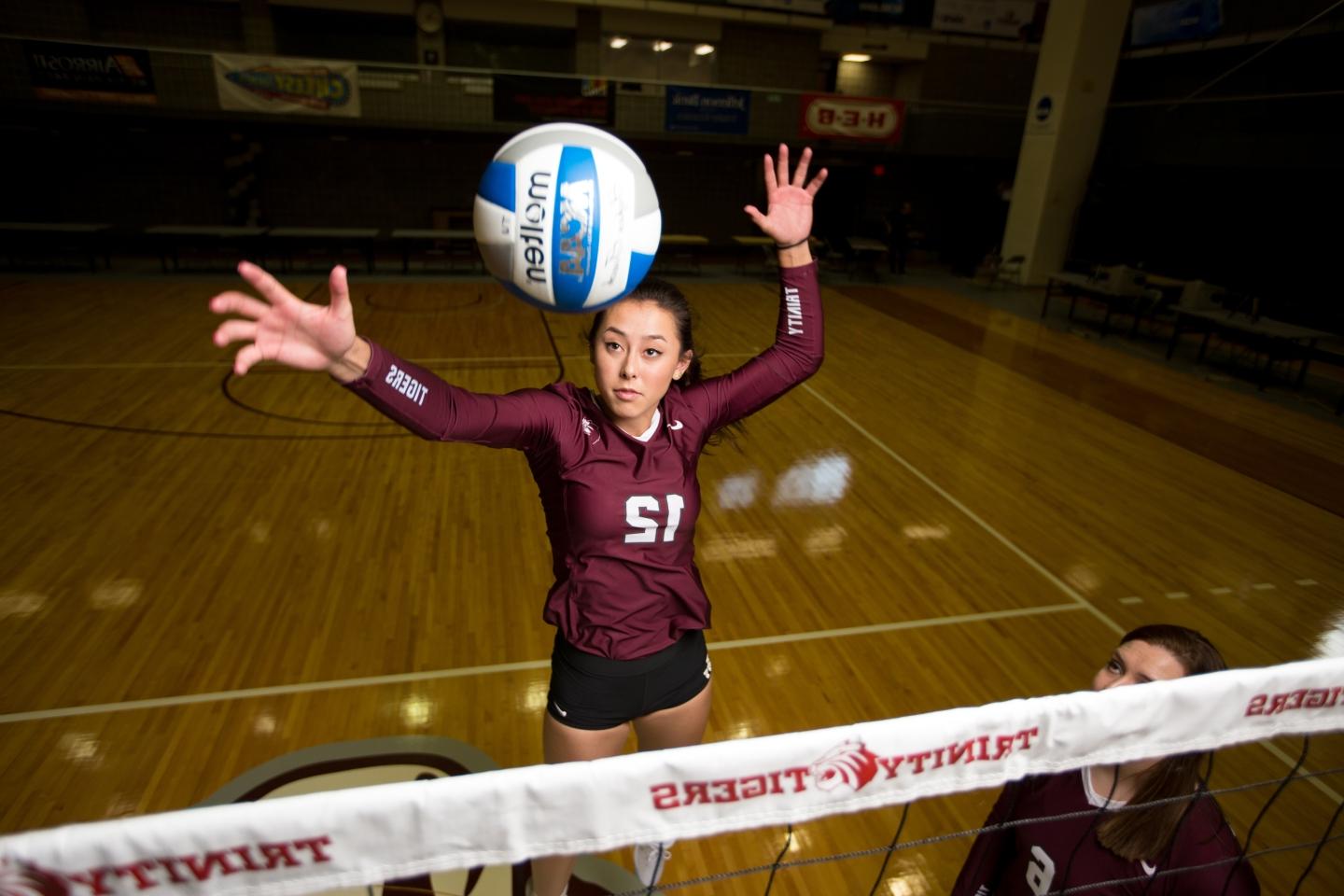 Jade Schoenberger spikes a volleyball over a net