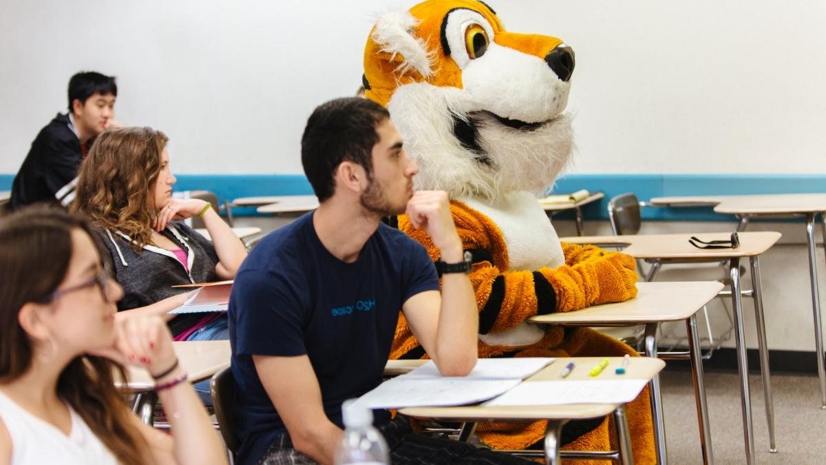 photo of Leroy sitting in a desk in a classroom with other students